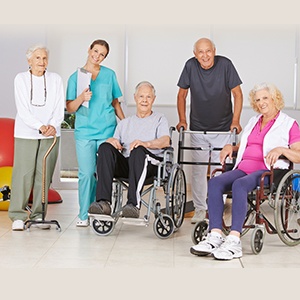 Group of happy senior people at physiotherapy in a nursing home with geriatric nurse